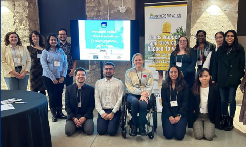People posing in front of banners at a community event