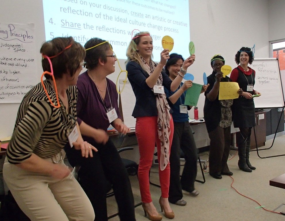 6 Alliance members stand in a line acting out their ideal care future using arts and crafts..
