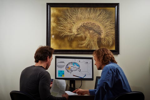 Two men in front of a computer.