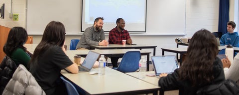Professor Eric Lepp sits beside Sami, a guest speaker during a class at Grebel