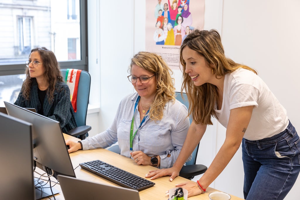 Lorena Rodriguez standing beside a desk with a colleague