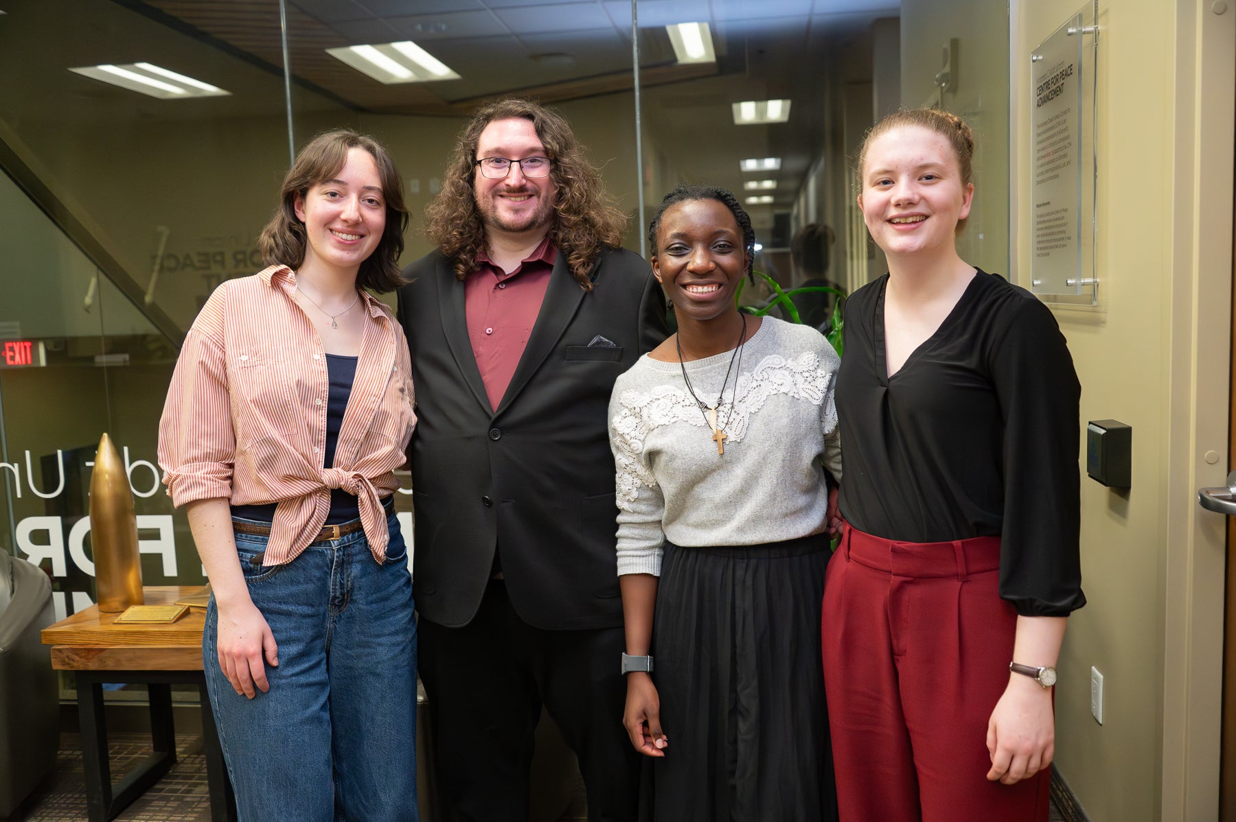 The contestants stand next to each other posing for a group photo