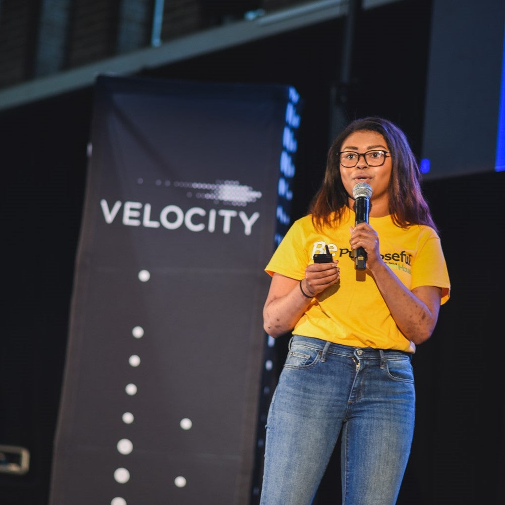 Cassie giving presentation in front of Velocity sign
