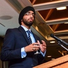 Raj speaking in front of microphone