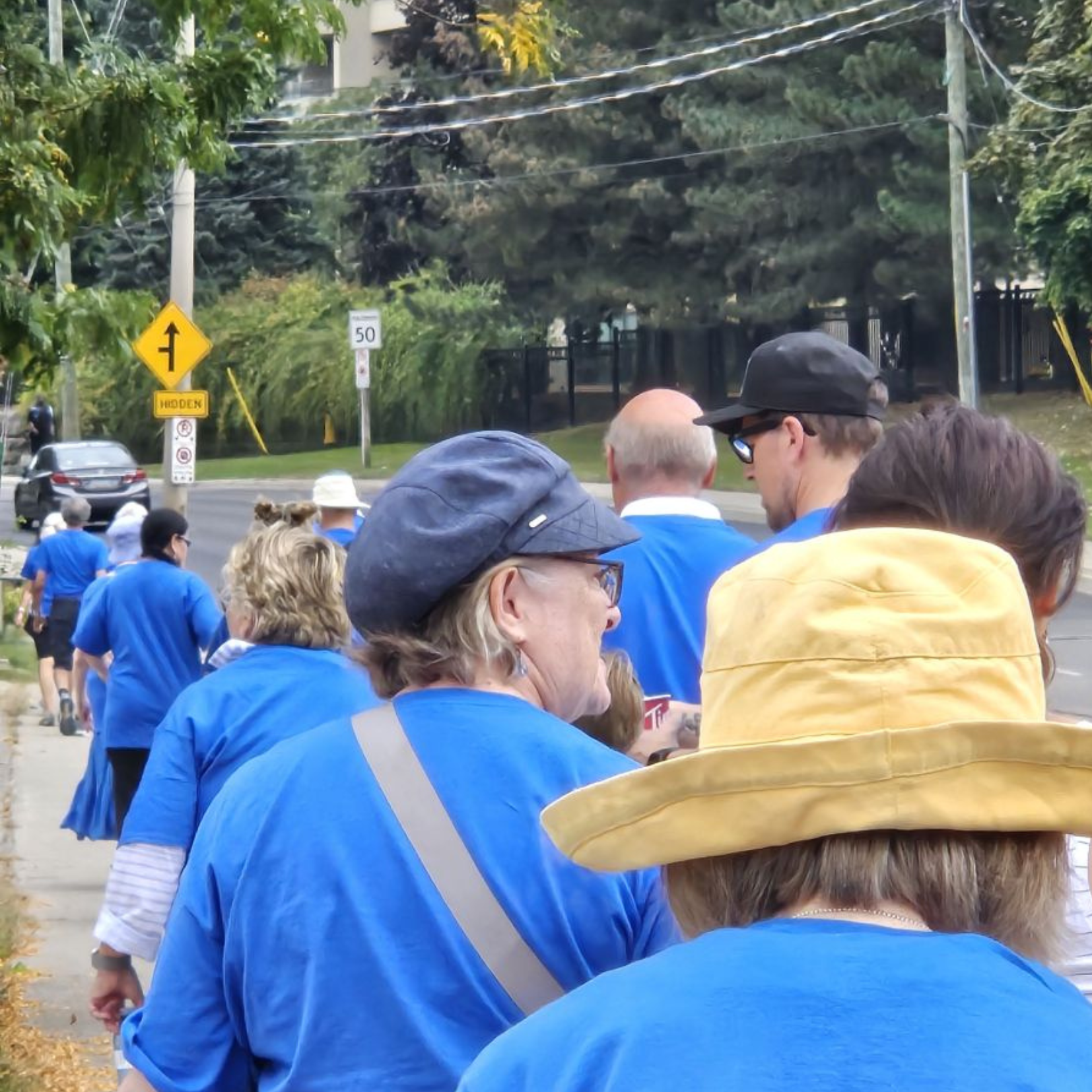 People walking while wearing blue shirts