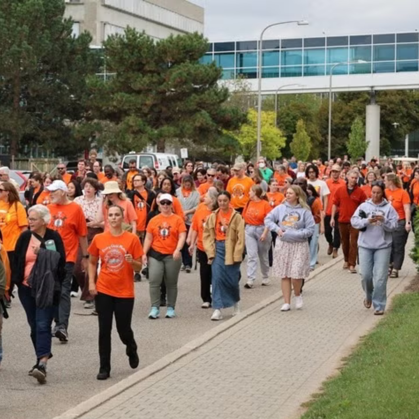 People walking while wearing orange shirts