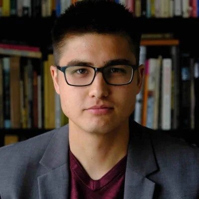 Galen sitting in front of a bookcase