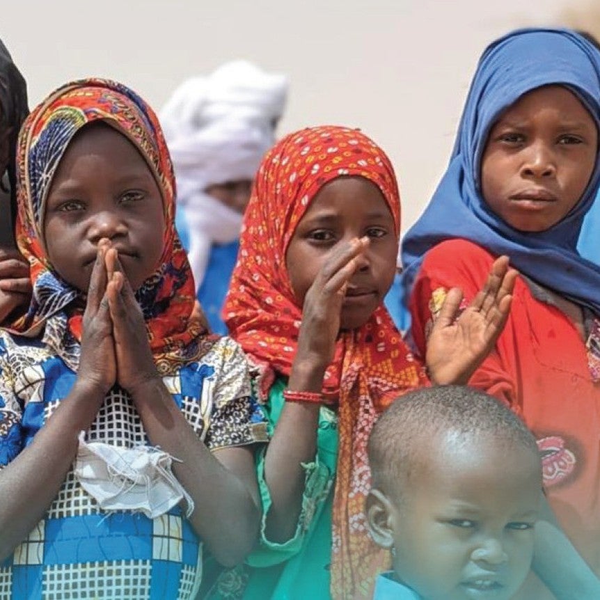 Four refugee children look into the camera