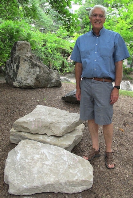 Columbus limestone in the Rock Garden with a man next to it.