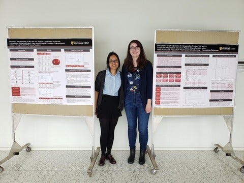 Two female students standing with research posters