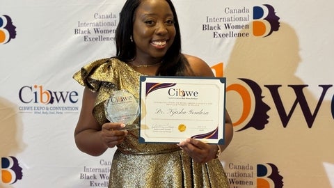 Nyasha Gondora holding up an award