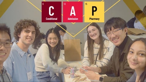 Students smiling behind graphic with an acronym that read Conditional Admission to Pharmacy