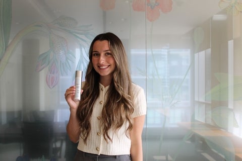 Emily Harper holding up a Rafino Skin product