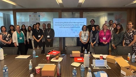 A group of people in a room smiling