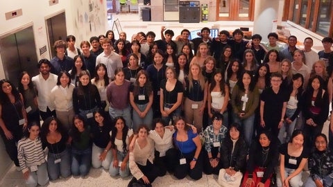A large group of students smiling a lobby