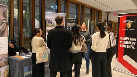 A group of people standing at a booth in discussion
