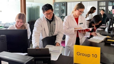 Students in a lab consulting documents