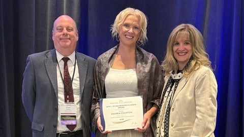 Dr. Edginton holding up the 2026 AFPC Research Career Award