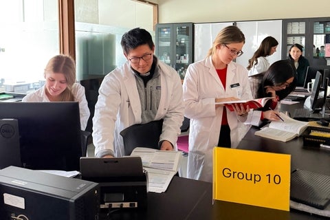 Students in a lab consulting documents