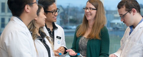 Pharmacy students and professionals talking in a group.