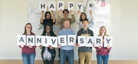Students and staff holding signs that spell happy anniversary