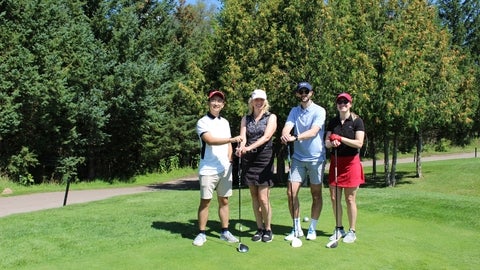 Four alumni on a golf course