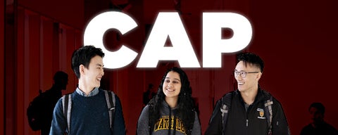 Three current CAP students in front of CAP banner.