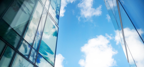 Pharmacy building with bright blue sky and fluffy white clouds.