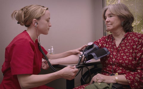 nurse checking woman's blood pressure