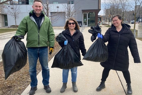 Three staff holding garbage bags