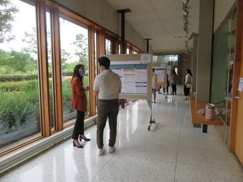 Two people standing side by side reading a presentation board