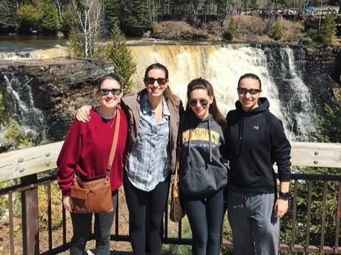 Dani Thomas and group smiling by waterfall lookout