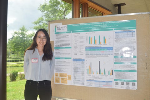 Lisa Ros-Choi standing next to a poster