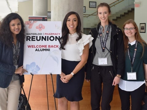 4 women smiling near a sign that reads "reunion"