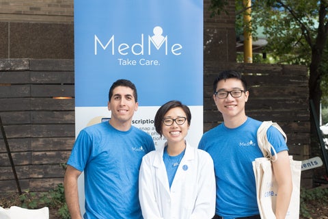 Three people standing in front of a MedMe banner smiling