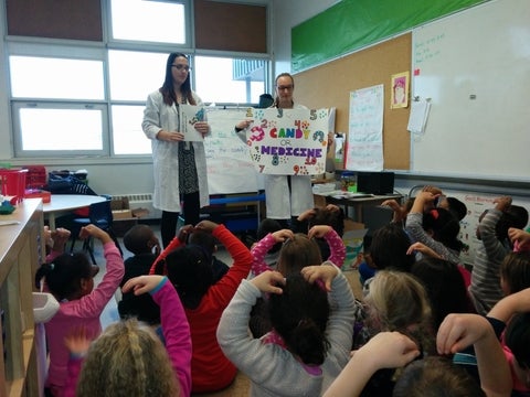 Two co-op students talking to an elementary class
