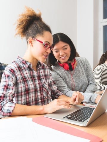 Two students chatting and looking at computer