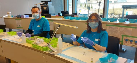 Ken Manson and Nancy Grindrod wearing PPE and working at the vaccine clinic 