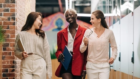 Three women walking and smiling