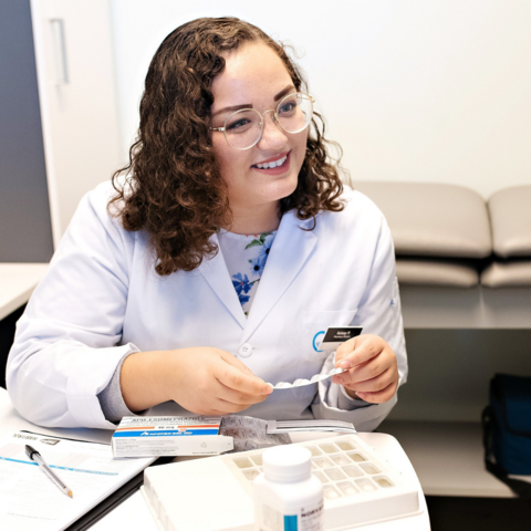 Pharmacist in white coat holding medicine