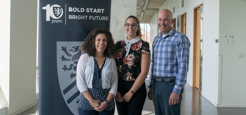 Barb, Nikki and Jeff in front of a School of Pharmacy banner that says Bold Start Bright Future