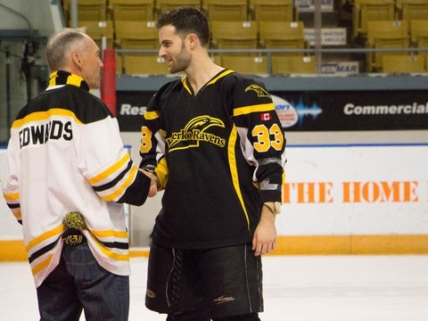 Hockey player shaking hands with director Edwards
