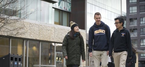 Beyond Limits: Students walk on the sidewalk outside the school.
