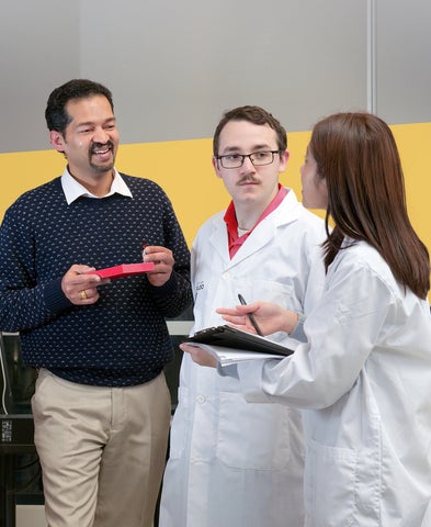 Praveen Nekkar and two students with yellow decal