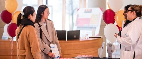 prospective students chatting with school of pharmacy representatives