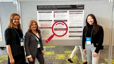 Three women smiling standing in front of board