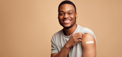 a man rolling up his sleeve and showing a vaccination band-aid a man rolling up his sleeve and showing a vaccination band-aid