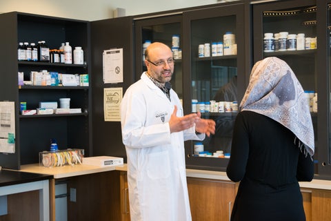 Wasem helping a patient at the pharmacy