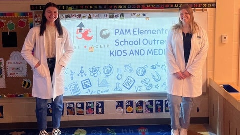 Viktoria Cubelic and Megan Taylor standing in front of a classroom