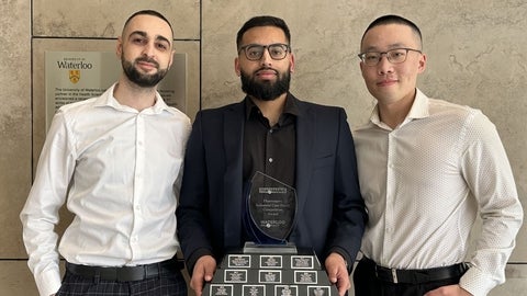 Three students holding an award